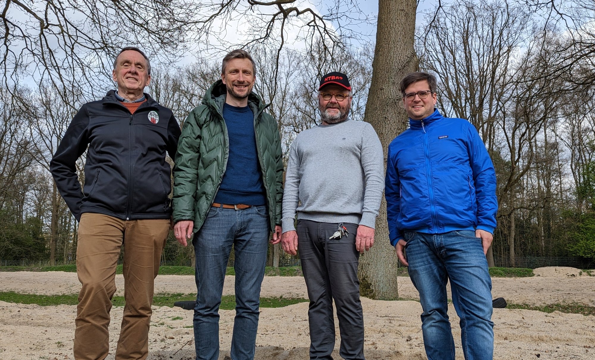 Hans Schreckenberg (HTB 62), Philipp Noß (SPD), Dirk Pommerening (HTB 62) und Timo B. Kranz (GRÜNE) im Kiwittsmoorbad vor den Beachvolleyballfeldern