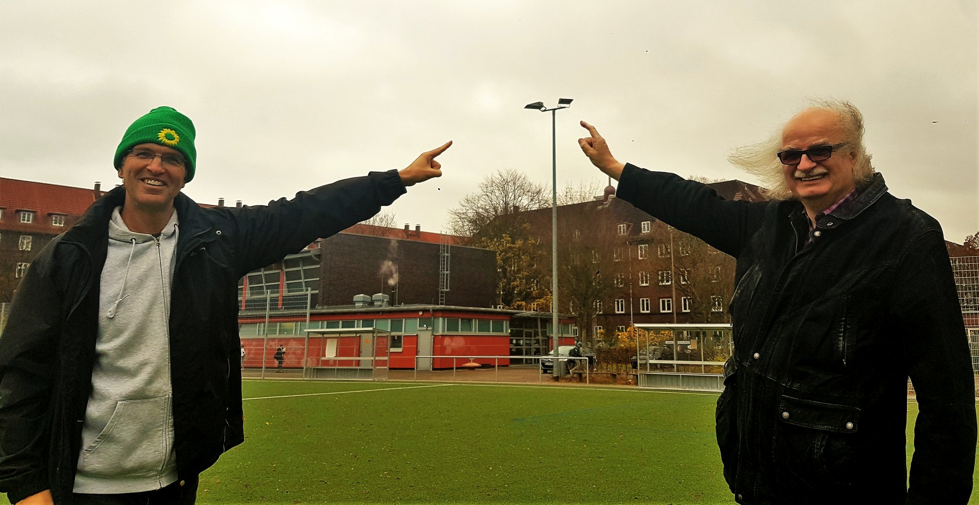 Oliver Camp (l., GRÜNE) und Ulrich Bunsmann (DSC Hanseat) auf dem Sportplatz