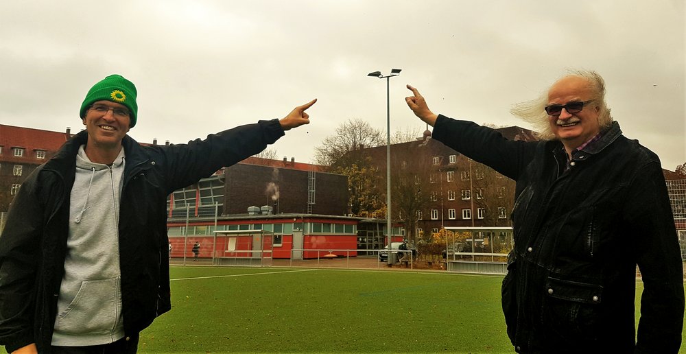 Oliver Camp (l., GRÜNE) und Ulrich Bunsmann (DSC Hanseat) auf dem Sportplatz